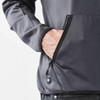 A close-up of a men's polar fleece jacket in grey, featuring a front pocket and a logo.