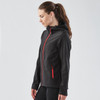 A black softshell hoody with red zippers and a hood, featuring a logo on the chest.