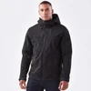 A black softshell jacket features a hood, zippered pockets, and a branding logo. Suitable for outdoor wear.