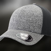A grey and black trucker cap featuring a textured design and a branded sticker on the brim.