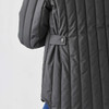 A thermal jacket in dark grey with quilted texture and button detail on the sleeve. It features a relaxed fit.