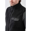 A men's black Sherpa fleece vest featuring a zip-up front and a snap-button pocket. The vest has a logo.