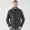 A man wearing a black softshell jacket with a zip front and side pockets, standing against a plain background.