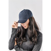 A navy Explorer Cap displayed on a model with long hair, featuring a simple design and a logo.