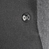 A close-up of a black button on a grey fabric, featuring a simple embossed design.