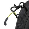 A close-up of a black backpack with a green accent on the zipper pull and a metal clip.