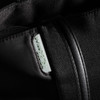 A black tote bag with a zipper and a prominent logo tag features a sleek, minimalist design.