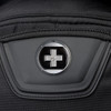 A close-up of a black backpack featuring a round logo on a zippered pocket.
