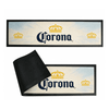 A rubber bar mat featuring a light background with black and yellow branding, including a logo, and a textured underside.