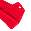 A red cotton golf towel with a label and a soft texture, folded to show its edges.