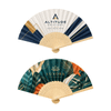 A bamboo hand fan featuring a logo, one side with a geometric design and the other with tropical foliage.