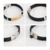 A stainless steel buckle latch bracelet featuring a braided black band and a gold-toned decorative bar.