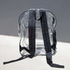 A transparent backpack with black straps and a simple design, featuring a logo.