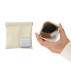 A small, cream cosmetic bag with a zipper, holding earbuds and a compact inside.