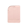 A pink silicone hair straightener pad with a textured wave design for heat protection and stability.