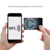 A hand holds a NFC PVC business card beside a smartphone displaying an NFC symbol. The card is black with a logo.