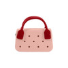A pink mini handbag with red handles featuring circular holes along the front. It has a simple, stylish design.