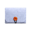 A grey felt essential oil bag with an orange button closure. It features a simple, compact design.