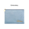 A durable flat makeup bag in soft blue with a gold embroidered logo and a zip closure.