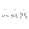 Three hair clip bows in white and brown patterns, featuring different styles with varying ribbon arrangements.