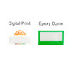 Two custom reusable acrylic name badges: one in white with an orange design and one in green with a simple shape.