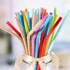 A jar filled with a variety of colourful, bendable, disposable 3-ply drinking paper straws.