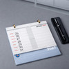 A desk calendar featuring a blue base with white pages, including a ring binding and a silver pen beside it.