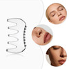A silver, multi-pronged scraping board with rounded edges, surrounded by images of natural facial features.