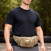 A camouflaged tactical fanny pack worn by a person in a black T-shirt, set against a natural background.