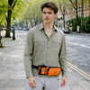 A drink bottle holder fanny pack in orange and black, worn by a man in a green shirt, set on a city street.