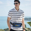 A man wearing sunglasses and a striped polo shirt, showcasing a blue fanny pack with a logo.
