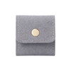 A grey synthetic leather jewellery bag with a gold button closure and stitched detailing.