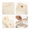 A mini synthetic leather jewellery bag in cream colour, featuring gold snap closures and interior compartments.