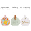 A set of three circular tags in pastel colours featuring different designs and logo branding.