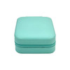 A turquoise PU leather jewellery box with a zippered closure and a textured finish. It features a logo on the surface.