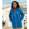 A blue women's rain jacket with a logo, featuring a zip and a hood, set against a scenic waterfront background.