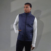 A navy lightweight packable insulated puffer vest features a front zip and a logo, worn over a long-sleeve top.
