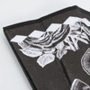 A bamboo fabric hand fan in black with white floral designs and a slim, folded structure. It features branding.
