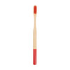 A colorful bamboo toothbrush with a red handle and a natural bamboo bristle head. It has a logo on the handle.