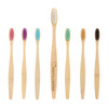 A large bamboo toothbrush with a wooden handle and various coloured nylon bristles, including white, purple, turquoise, and black.