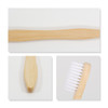 A large toothbrush with a wavy bamboo handle and soft white bristles, featuring a logo on the handle.