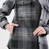 A women's shacket in grey and black Highland plaid with a front pocket and button closure. Features a logo.