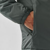 A dark green thermal jacket with a hand in the side pocket. The jacket features elasticated cuffs and a smooth exterior.
