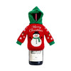 A drink bottle covered with a red and green knitted wine bottle cover featuring a snowman design.
