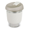 A drink bottle featuring a clear body with a beige, textured lid and a white silicone sleeve.