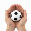 A high bounce soccer ball in white with black pentagon panels, held in two hands.