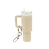 A drink bottle keyring in beige, featuring a straw and a handle, with a keychain attachment.