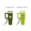 A miniature tumbler keyring in green with a white lid, featuring different print designs and a keychain attachment.