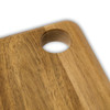 A wooden serving board with a natural acacia finish and a circular cut-out in one corner.
