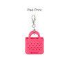 A pink mini EVA holes bag keychain with a silver clip, featuring a simple handbag design and branding.